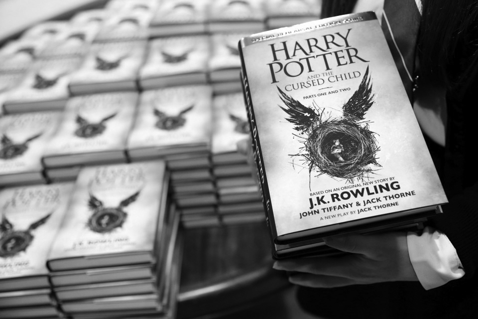 A store assistant holds copies of the book of the play of Harry Potter and the Cursed Child parts One and Two at a bookstore in London, Britain July 31, 2016. REUTERS/Neil Hall - RTSKER4